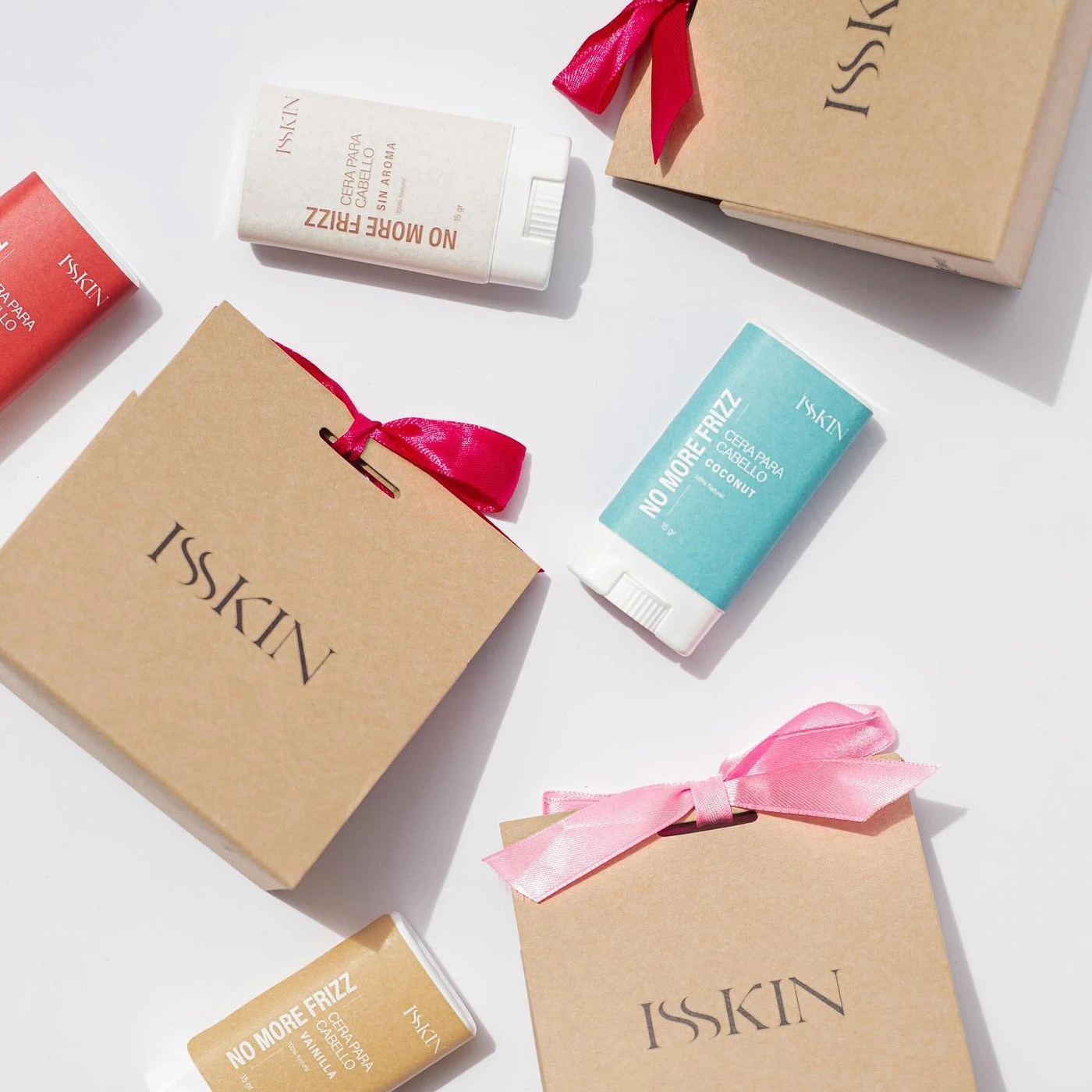 Bolsas kraft de Isskin con moños rosados sobre fondo blanco